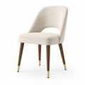Chaise en tissu bouclé beige avec pieds en bois et embouts dorés